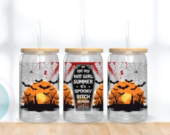 May include: Clear glass can-shaped tumbler with a bamboo lid and straw. The tumbler features a Halloween-themed design with a spiderweb, bats, and a coffin-shaped graphic that reads "Move Over Hot Girl Summer It's Spooky Bitch Season."