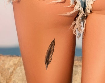 May include: A woman wearing denim shorts with a small feather tattoo on her thigh.