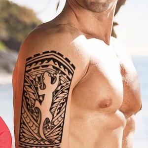Op de afbeelding: Een stel op een strand, de man heeft een tijdelijke tatoeage op zijn bovenarm van een zwart-witte hagedis met tribale ontwerpen. De vrouw draagt een rode bikini top.