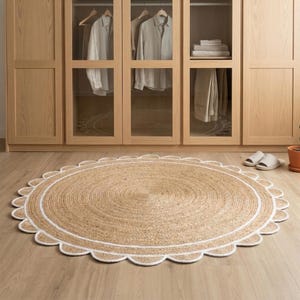 May include: A round jute rug with a scalloped white border. The rug is placed on a light wood floor in front of a wooden wardrobe with glass doors. The rug's diameter is approximately 60 inches.