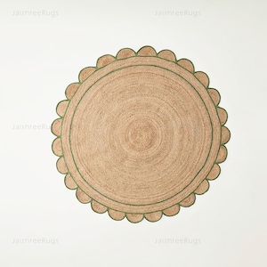 May include: Round jute rug with a scalloped edge and a green border. The rug has a natural, woven texture and a circular design. The rug is approximately 60 inches in diameter.