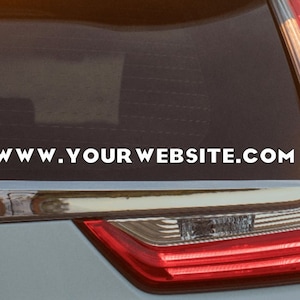 May include: A gray car with a rear window that has a white website address sticker that says "www.yourwebsite.com".