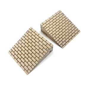 May include: Two light-colored wooden wedge ramps featuring a printed brick pattern on the top surface. Each ramp has a sloped design with visible side panels and the word SESSION printed in black on the side of the upper ramp structure.