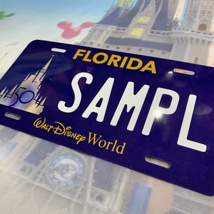 Puede incluir: Placa de matrícula azul oscuro con la palabra "FLORIDA" en amarillo en la parte superior. La palabra "SAMPL" está en letras blancas grandes. La parte inferior tiene "Walt Disney World" en dorado. Un gráfico de castillo está a la izquierda.