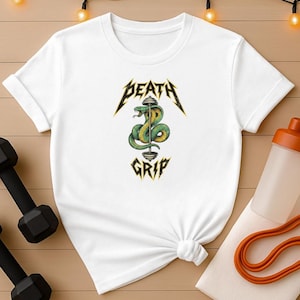 May include: White t-shirt featuring a graphic of a green and yellow snake coiled around a barbell, with the words "DEATH GRIP" in a stylized font. The shirt is a crew neck and has short sleeves. Fitness and workout apparel.