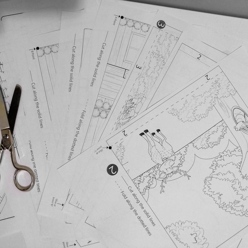 May include: A black and white printable paper craft with instructions to cut and fold along the solid and dotted lines. The craft features a deer with antlers and a forest scene.