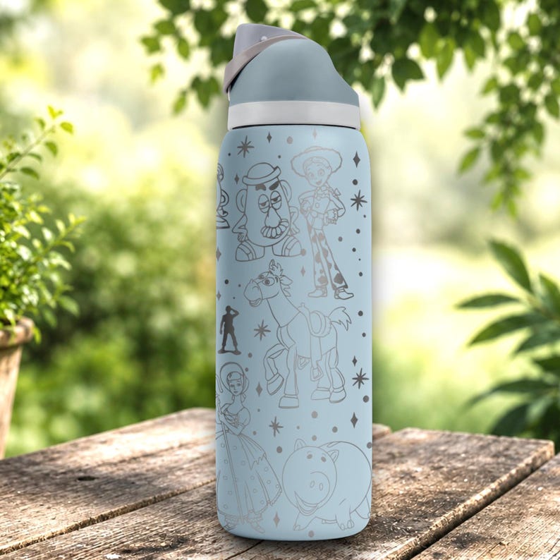 May include: A light blue water bottle featuring a grey lid and a wrap-around line art print of various animated characters including a potato figure, a cowgirl, a horse, a small soldier, a woman in a dress, and a pig, accented with small star shapes.