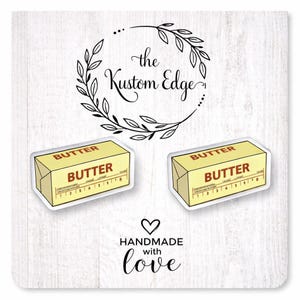 May include: Two stickers with a butter stick design, featuring the word "BUTTER" in bold letters. The stickers are yellow and white, with measurement markings. The text "the Kustom Edge" and "HANDMADE with love" are also present.