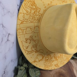 Beauty and the Beast engraving Vegan Suede Hat in a flat-lay shot, an engraved western fedora.