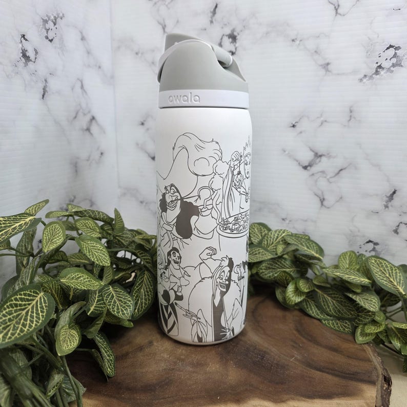 Puede incluir: Botella de agua aislada blanca con tapa gris e ilustraci&oacute;n en blanco y negro de villanos de Disney. La botella tiene la palabra "awala" impresa. La botella es cil&iacute;ndrica y parece ser de acero inoxidable.