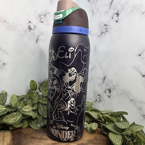Puede incluir: Una botella de agua Owala azul oscuro con contornos plateados de villanos de Disney. La botella tiene una tapa marr&oacute;n y verde con el texto "Ultra Unlock". El texto "Eli" y "Disney Wonder" tambi&eacute;n son visibles.