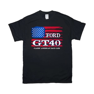 May include: Black t-shirt with a red, white, and blue American flag design. The text "FORD GT40" is printed in white on the shirt, with the words "CLASSIC AMERICAN RACE CARS" printed below.
