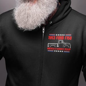 May include: A black zip-up hoodie with a white graphic of a 1953 Ford F150 pickup truck. The graphic includes the text "1953 Ford F150" and "America's Favorite Pickup".