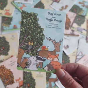 Op de afbeelding: Een blauwe kaart met de titel "Durf Dieren van Durfje Daantje" voor kinderen van 4 tot 10 jaar. De kaart toont een illustratie van een hert, een vos, een das, een konijn, een eekhoorn, een uil en een egel in een bosomgeving.