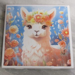 Puede incluir: Una llama blanca con una corona de flores en la cabeza. La llama está rodeada de flores en tonos rosa, naranja y amarillo. El fondo es azul claro con puntos blancos.