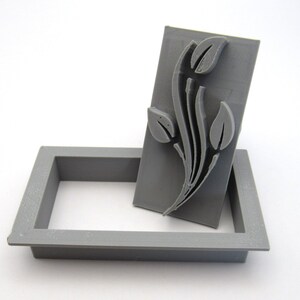 May include: A gray plastic stamp with a floral design, in a gray plastic case.