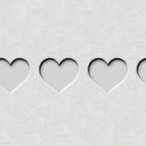 May include: Four white heart shapes cut out of a white paper background.