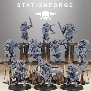 May include: A set of 10 grey plastic miniature figures of robots with various weapons and accessories. The figures are posed in a variety of action poses. The figures are all standing on black bases. The figures are all part of the Stationforge brand.