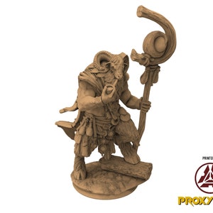 Könnte beinhalten: Eine detaillierte braune Miniaturfigur eines ziegenartigen Wesens mit Hörnern, das einen Stab mit einer runden Kugel oben hält. Die Figur steht auf einem runden Sockel.