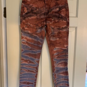 Könnte beinhalten: Eine blaue und braune Skinny Jeans mit Batik-Muster und ausgefranstem Saum.