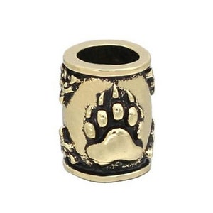 May include: Gold-colored metal bead with a bear paw print design. The bead has a black background and a gold-colored bear paw print in the center.