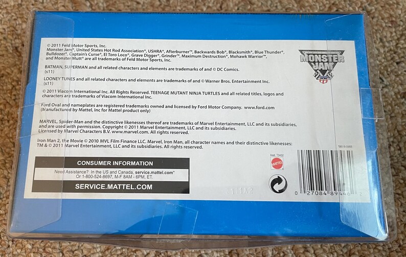 K&ouml;nnte beinhalten: Eine blaue Box mit Text, darunter "Monster Jam" und "Consumer Information". Die Box enth&auml;lt auch Logos f&uuml;r "Monster Jam" und Mattel. Der Text listet Marken und Urheberrechtsinformationen f&uuml;r verschiedene Marken auf.