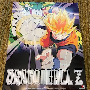Könnte beinhalten: Ein Poster mit Charakteren aus Dragon Ball Z. Das Bild zeigt zwei Charaktere in dynamischen Posen, wobei sich einer mit stacheligem gelbem Haar und einem orangefarbenen Gi im Vordergrund befindet. Das Dragon Ball Z-Logo ist prominent unten zu sehen.