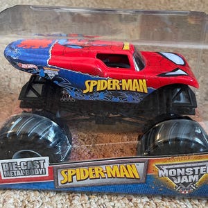 May include: A Spider-Man Monster Jam die-cast metal body truck toy. The truck is red and blue with the Spider-Man logo and graphics. The toy is in a clear plastic package.
