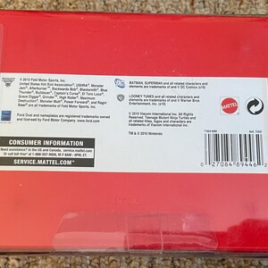 May include: A red box with white text and a barcode. The box contains information about the product, including the manufacturer, trademarks, and consumer information. The box is sealed with clear tape.