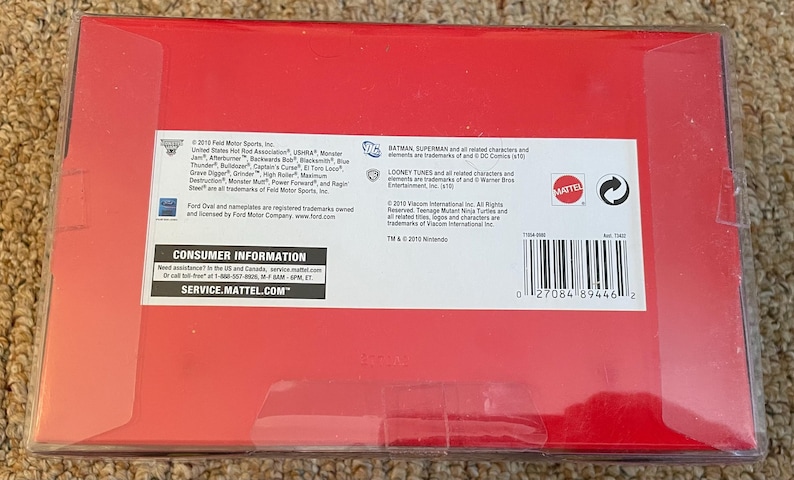 May include: A red box with white text and a barcode. The box contains information about the product, including the manufacturer, trademarks, and consumer information. The box is sealed with clear tape.