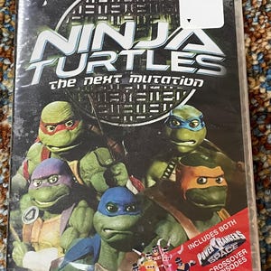 May include: A DVD case for "Ninja Turtles: The Next Mutation" featuring the Teenage Mutant Ninja Turtles. The cover includes the text "Turtle Power!" and "Includes Both Power Rangers Space Crossover Episodes."