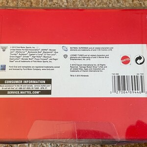 May include: A red box with white text and a barcode. The box contains information about the product, including the brand, trademarks, and consumer information. The box is in a clear plastic case.