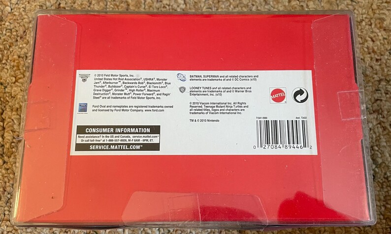 May include: A red box with white text and a barcode. The box contains information about the product, including the brand, trademarks, and consumer information. The box is in a clear plastic case.