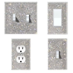 May include: Four decorative wall plates with a sparkly, iridescent finish. The plates are designed to cover standard light switch and outlet plates.