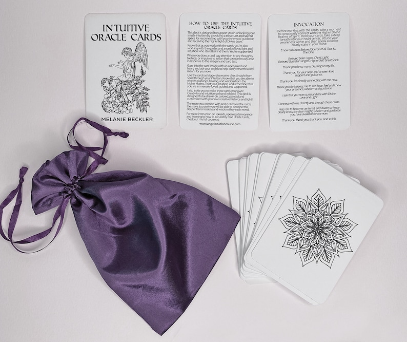 May include: A set of white oracle cards with black ink illustrations and text. The cards are in a purple satin bag. The cards include the title "Intuitive Oracle Cards" and the text "How to Use the Intuitive Oracle Cards" and "Invocation".