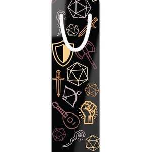 May include: Black bookmark with a white metal clip. The bookmark is decorated with a pattern of gold and pink line drawings of fantasy role-playing game icons, including dice, swords, shields, and a lute.