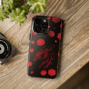 May include: Black phone case with a red dragon and red dice pattern.