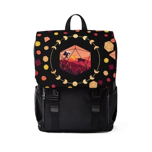 Puede incluir: Mochila negra con un diseño colorido que presenta un dado de 20 caras con dragones en su interior. El dado está rodeado por un círculo de lunas y dados.