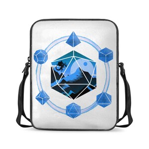 May include: A white canvas messenger bag featuring a blue and black graphic of a 20-sided die with a dragon flying over a mountain landscape. The die is surrounded by six smaller blue dice.