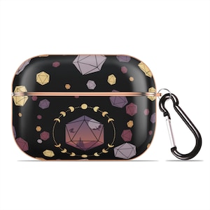 May include: Black Airpods case with a geometric pattern of dice and moons. The case has a rose gold trim and a black carabiner clip.