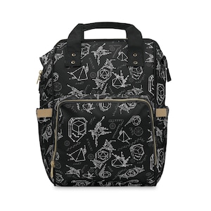 Puede incluir: Una mochila negra con un patrón geométrico de líneas y formas blancas. La mochila tiene un asa superior, dos correas de hombro ajustables y un bolsillo frontal con cremallera.