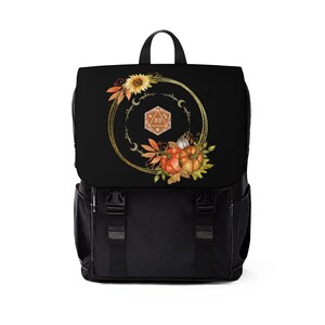 May include: Black backpack with a gold circle design featuring a 20-sided die, autumn leaves, pumpkins, and sunflowers.