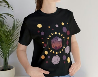 May include: Black t-shirt with a graphic of a purple and gold geometric dice with a sunset scene inside. The dice is surrounded by a circle of gold crescent moons.