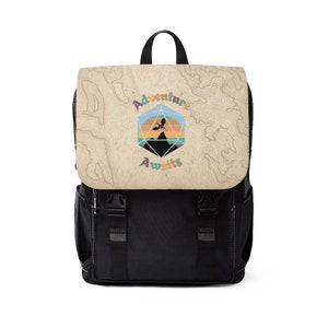 May include: A black backpack with a beige flap featuring a colorful graphic of a dragon flying over a mountain range inside a twenty-sided die. The text "Adventure Awaits" is written in a colorful font below the graphic.