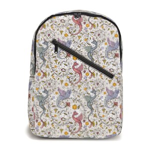 Puede incluir: Una mochila blanca con una cremallera negra y un bolsillo frontal. La mochila está cubierta con un patrón repetido de dragones coloridos y diseños florales.