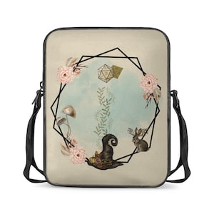 May include: A beige laptop sleeve with a black strap. The front features a geometric design with a 20-sided die, mushrooms, a rabbit, and flowers.