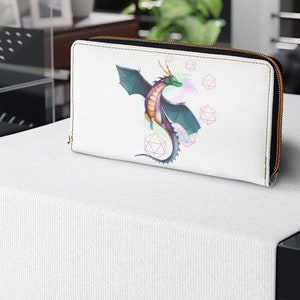 Könnte beinhalten: Eine weiße Reißverschlusstasche mit einem bunten Drachen und geometrischen Formen, die auf der Vorderseite aufgedruckt sind.