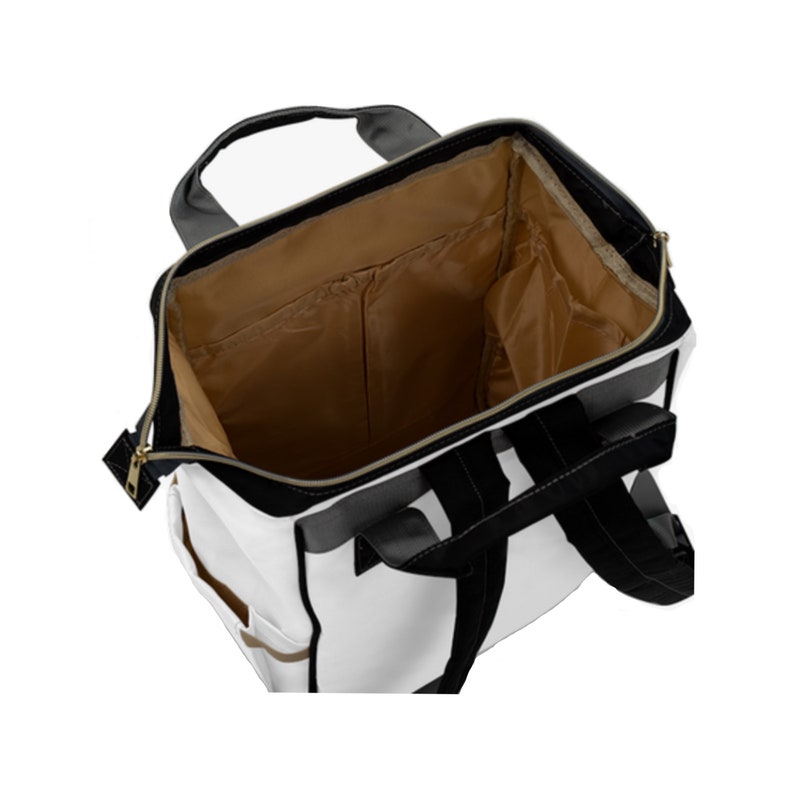 May include: White and black canvas backpack with a brown interior. The backpack has a zip closure and multiple pockets.