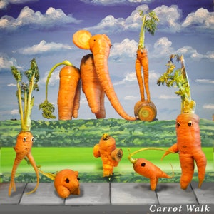 May include: A whimsical scene featuring carrots arranged to look like animals. An orange carrot elephant with a long trunk stands on a green surface, with a smaller orange carrot dog sitting in front of it. A tall orange carrot person with long legs stands in the background, and a smaller orange carrot dog with a long tail sits in the foreground. The text "Carrot Walk" is written in black letters at the bottom of the image.