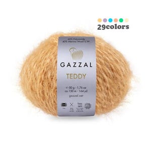 Könnte beinhalten: Ein Knäuel GAZZAL TEDDY Garn in hellbrauner Farbe. Das Garn besteht aus 60% Polyamid und 40% Merinowolle. Das Knäuel wiegt 50 Gramm und enthält 150 Meter Garn.